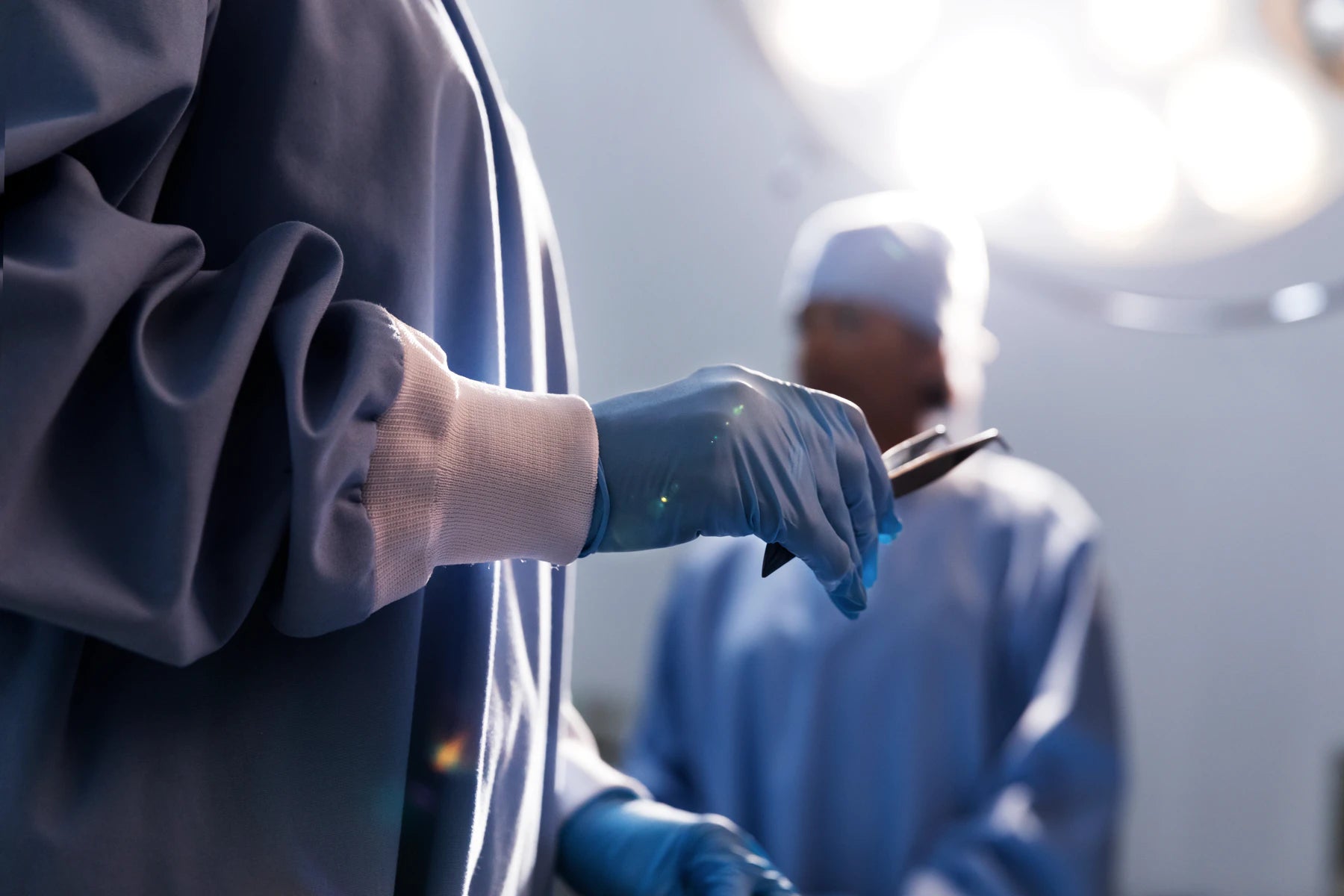 doctor sosteniendo unas pinzas de cirugia con ropa medica quirurgica